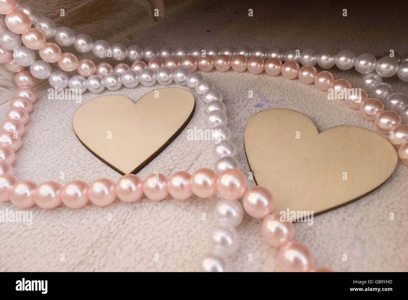 Beautiful wooden heart shapes with necklaces as decorations. Stock Photo