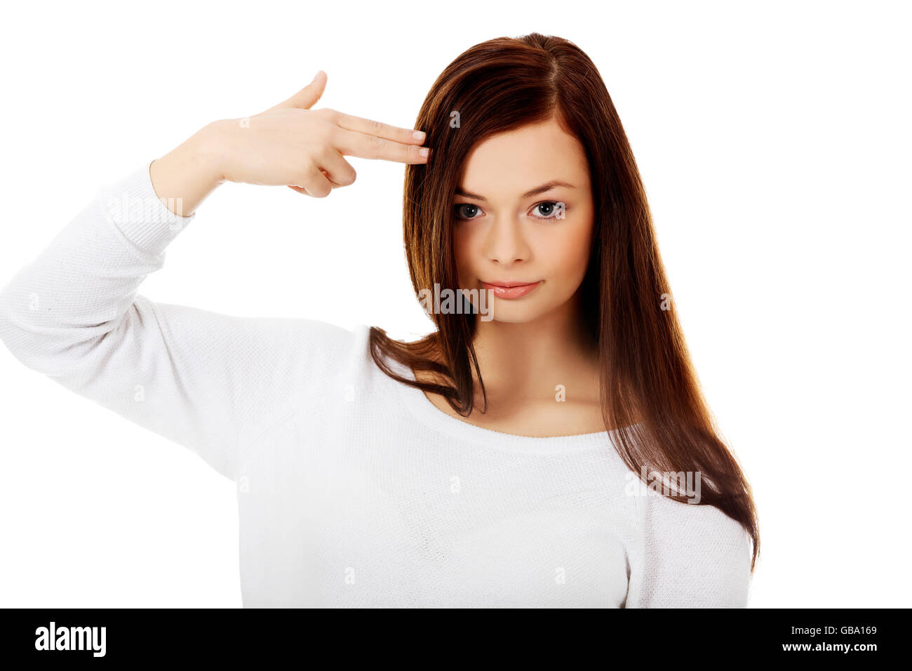 Young woman shoots herself in the head with finger gun gesture Stock Photo
