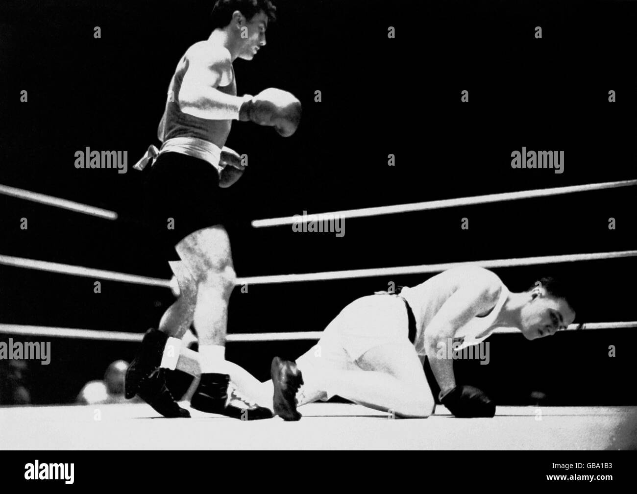Gold medallist Laszlo Papp of Hungary (l) stands over Great Britain's John Wright (r) after knocking him down Stock Photo