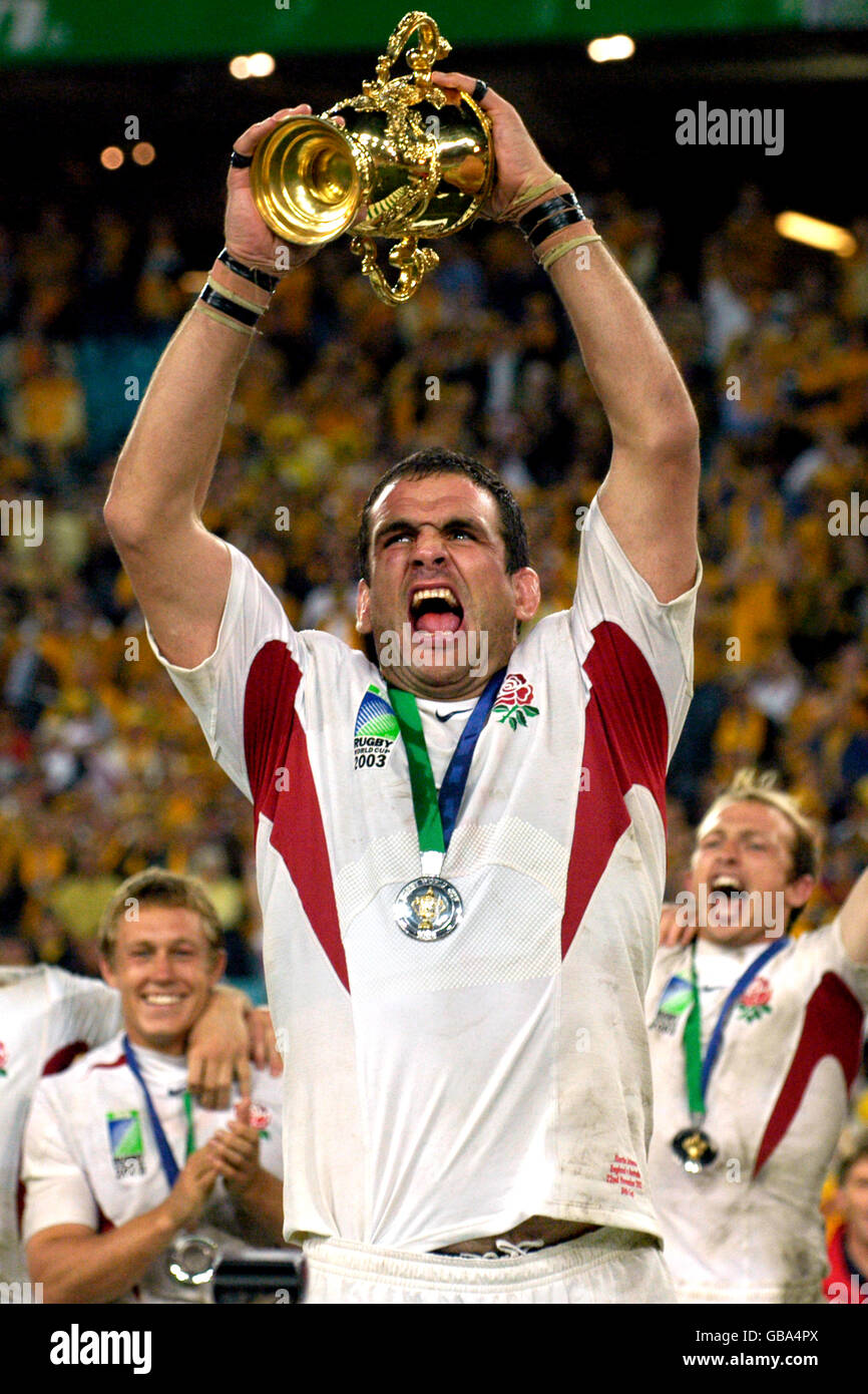 England captain Martin Johnson celebrates with the World Cup Webb Ellis trophy much to the delight of his players. Stock Photo