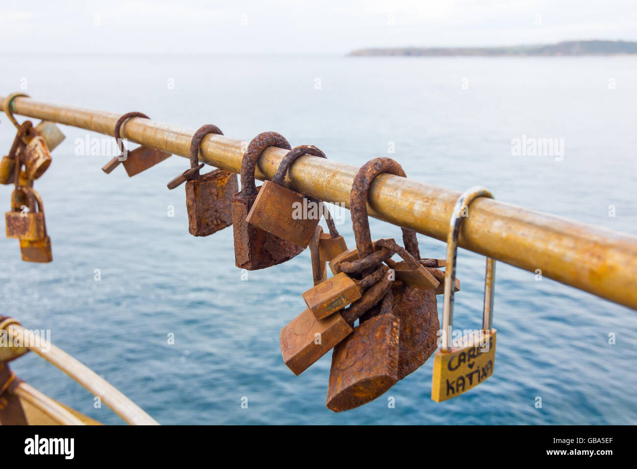 Rusty padlocks on a railing by the sea Stock Photo