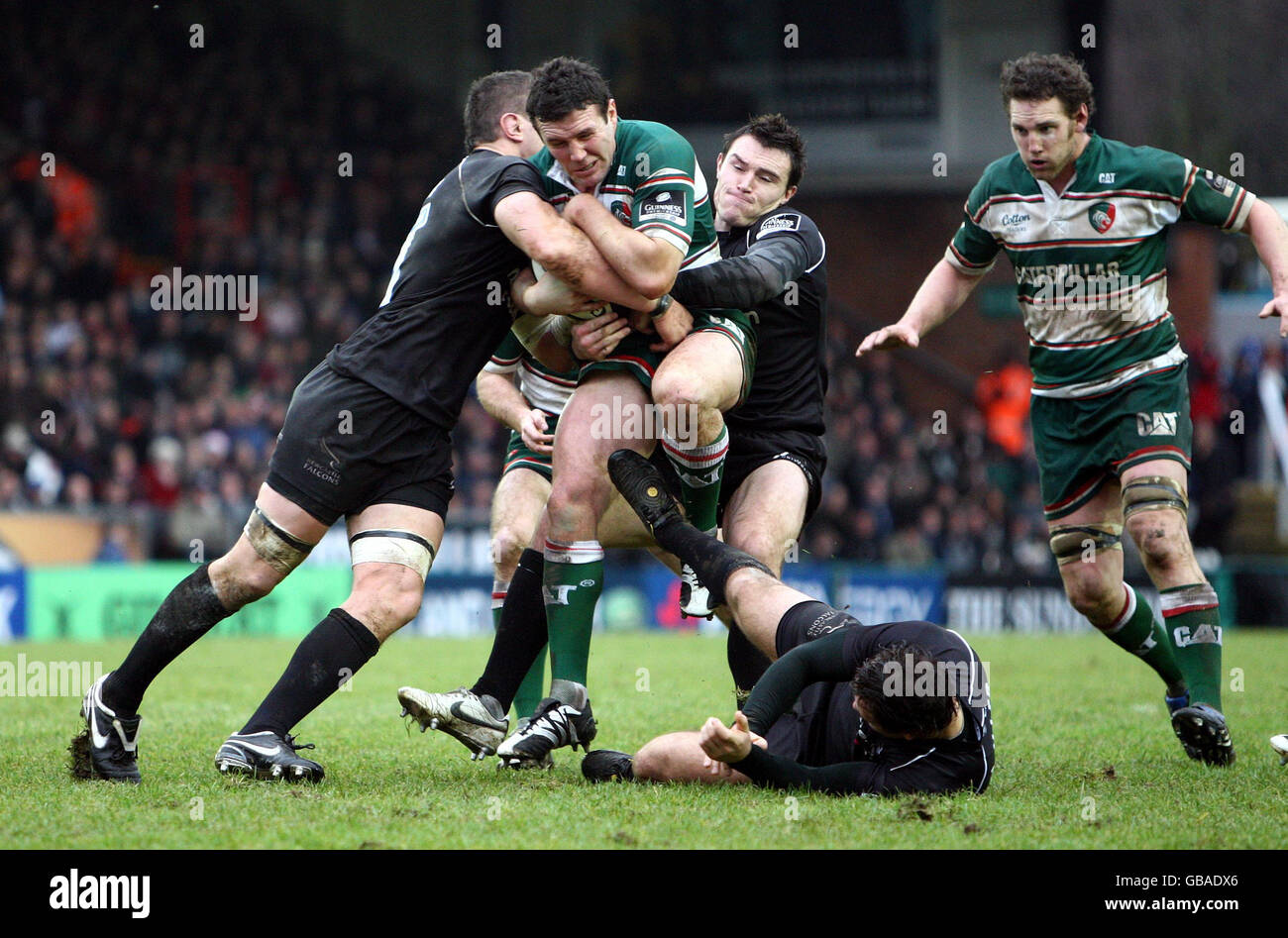 Leicester Tigers' Aaron Mauger (centre) is held as he tries to break