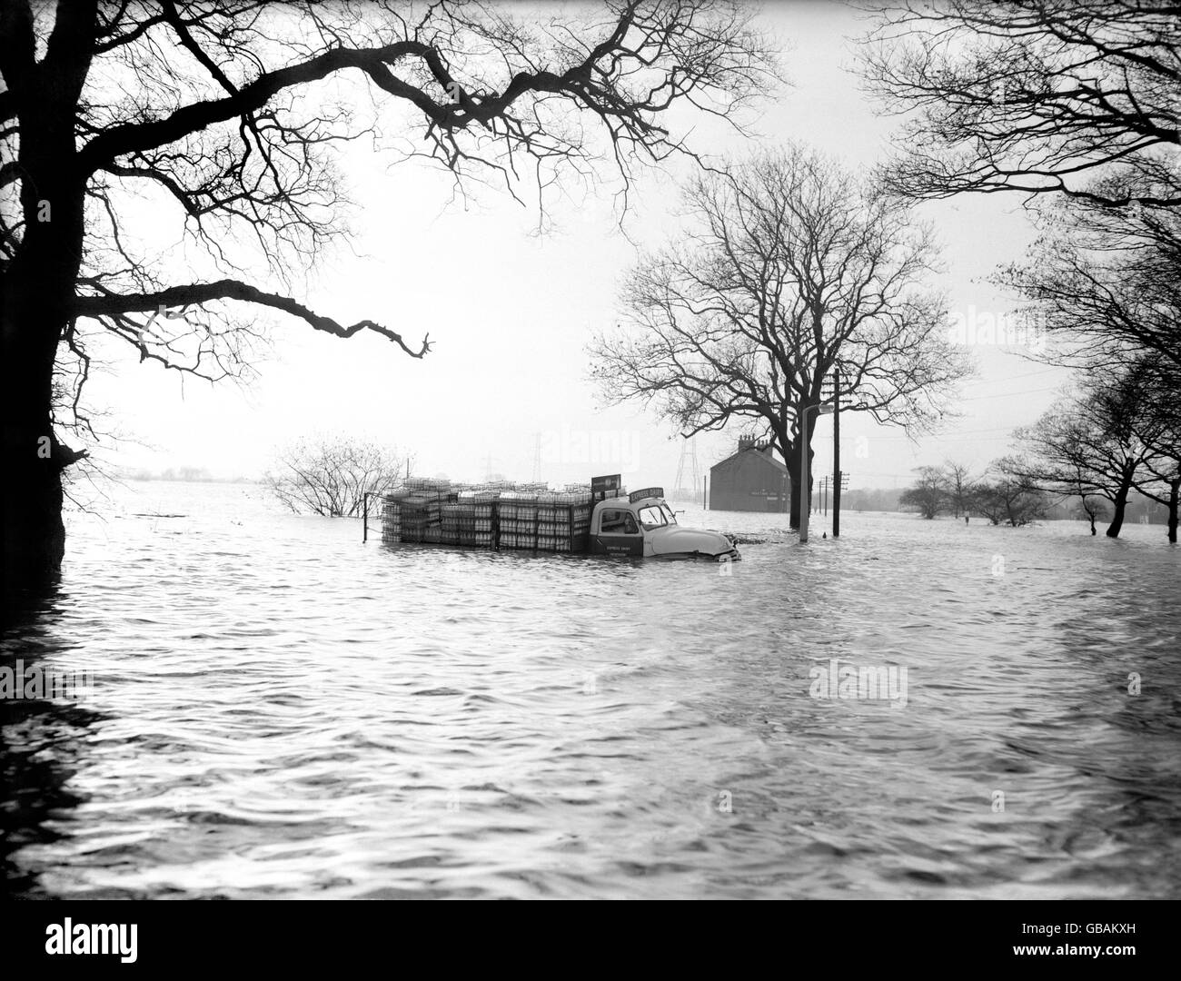 With its wheels completely submerged, a milk float is stranded in deep floods at Methley, near Leeds, Yorkshire. Stock Photo