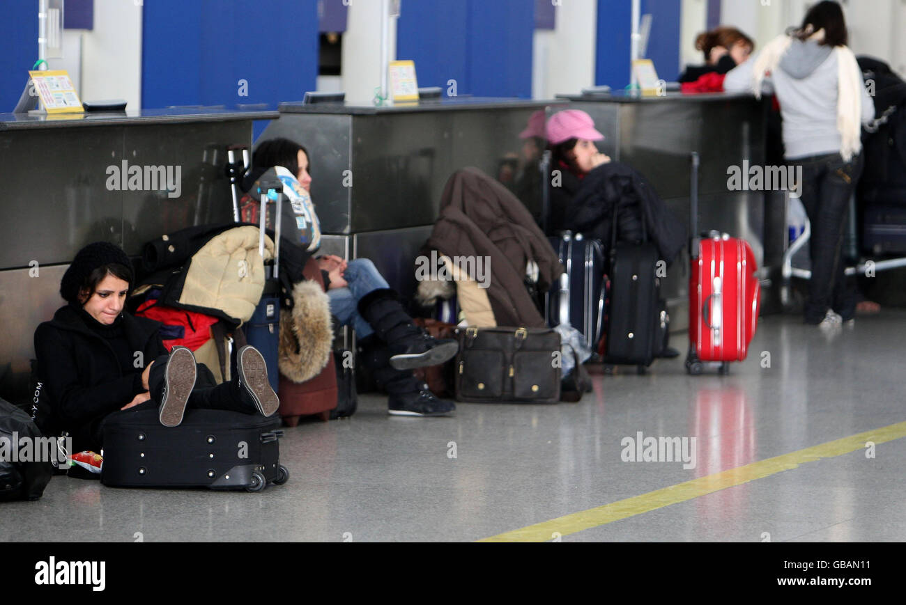Passengers wait at Ryan Air checkin desks at Stansted Airport, Essex