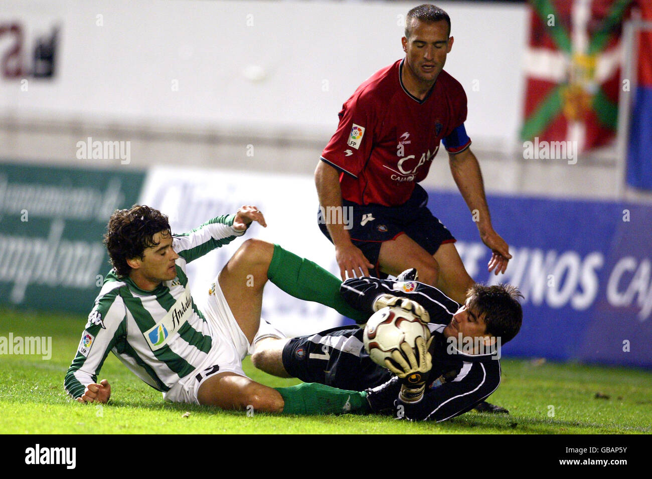 Osasuna's Jose Manuel Mateo watches his goalkeeper Ricardo Sanzol Goni challenge with Real Betis's Jorge Lopez Tote for the ball Stock Photo