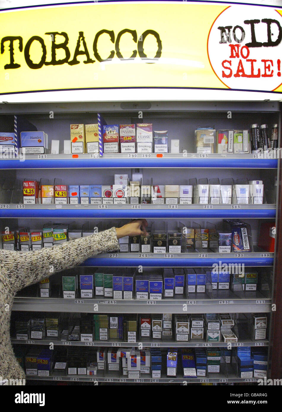 A shop assistant in Portsmouth reaches for a packet of cigarettes. Health Secretary Alan Johnson today unveiled plans to force cigarette sales 'under the counter' in a bid to cut smoking by children. Stock Photo