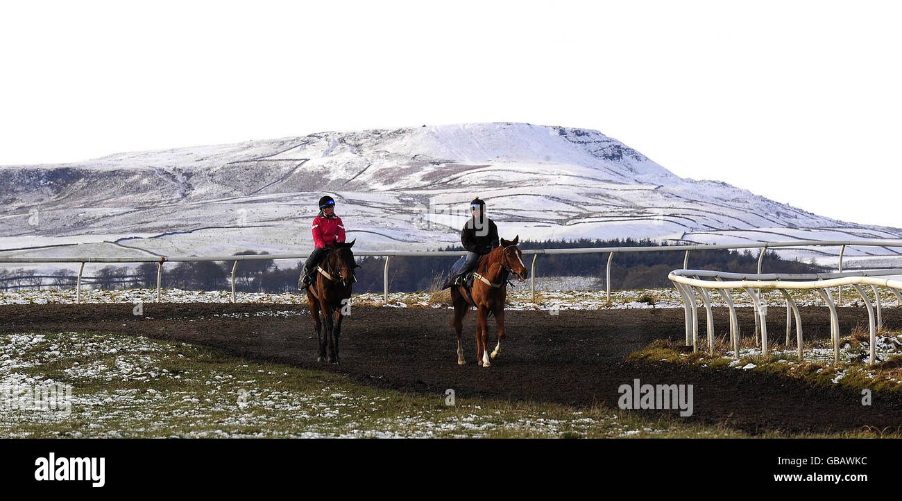 Horse Racing - Weather. Cold work as riders exercise racehorses on the moors above West Witton in Wensleydale as the snow and low temperatures continue. Stock Photo