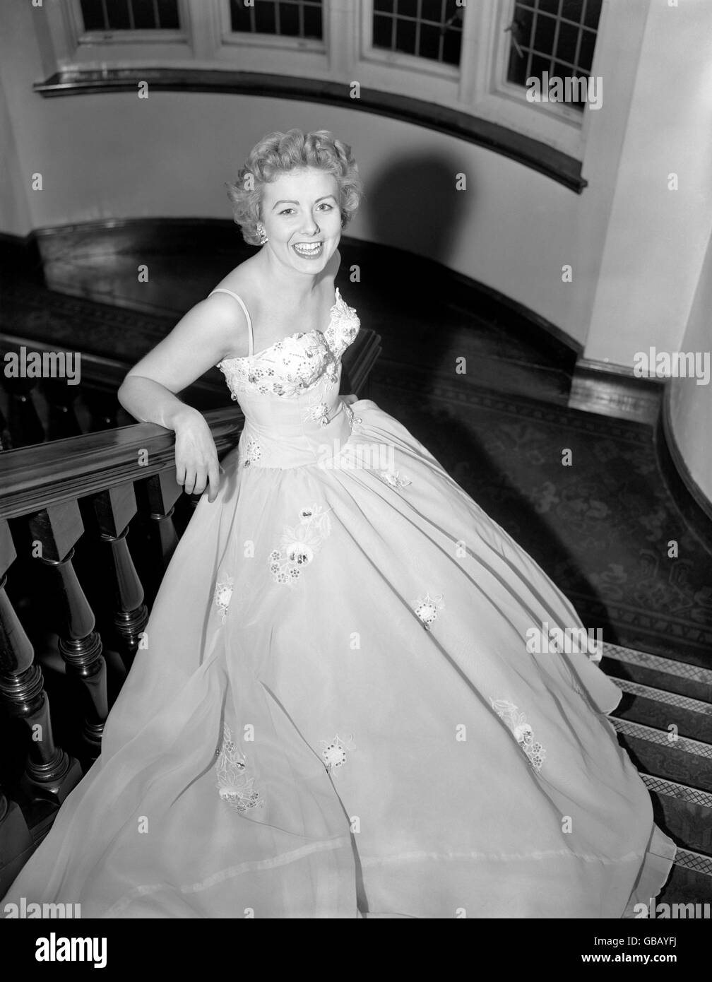 Singer Edna Savage was trying on a new evening gown in her London hotel before flying out to Cyprus to spend a month entertaining the troops. The dress is of ice blue nylon with a white floral motif, encrusted with sequins, pearls and diamante. Stock Photo
