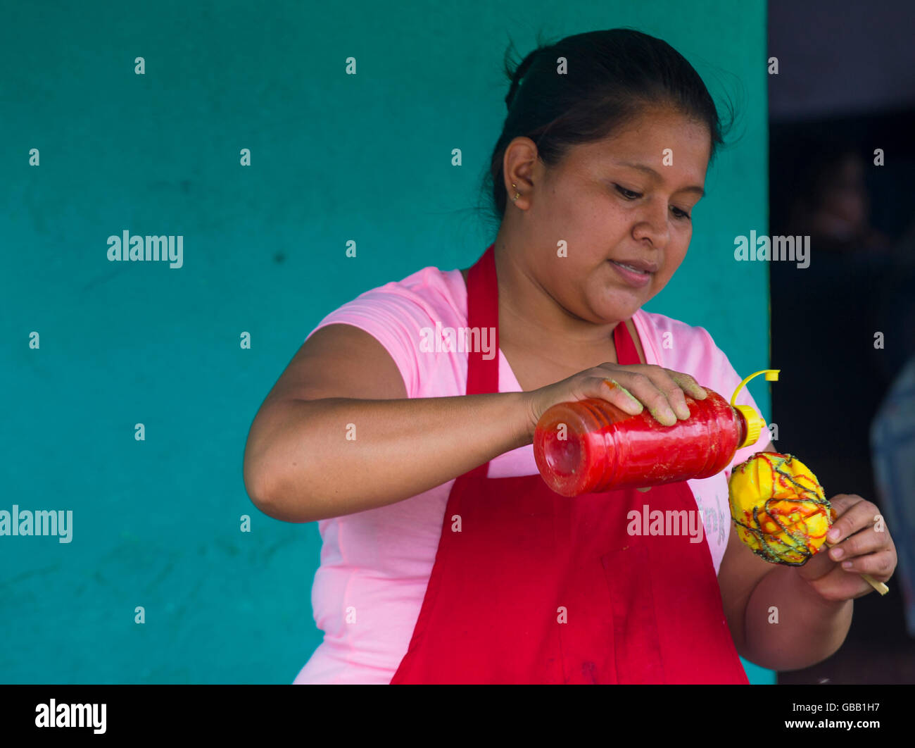 A Salvadoran woman sells mango on a stick during the Flower & Palm Festival in Panchimalco, El Salvador Stock Photo