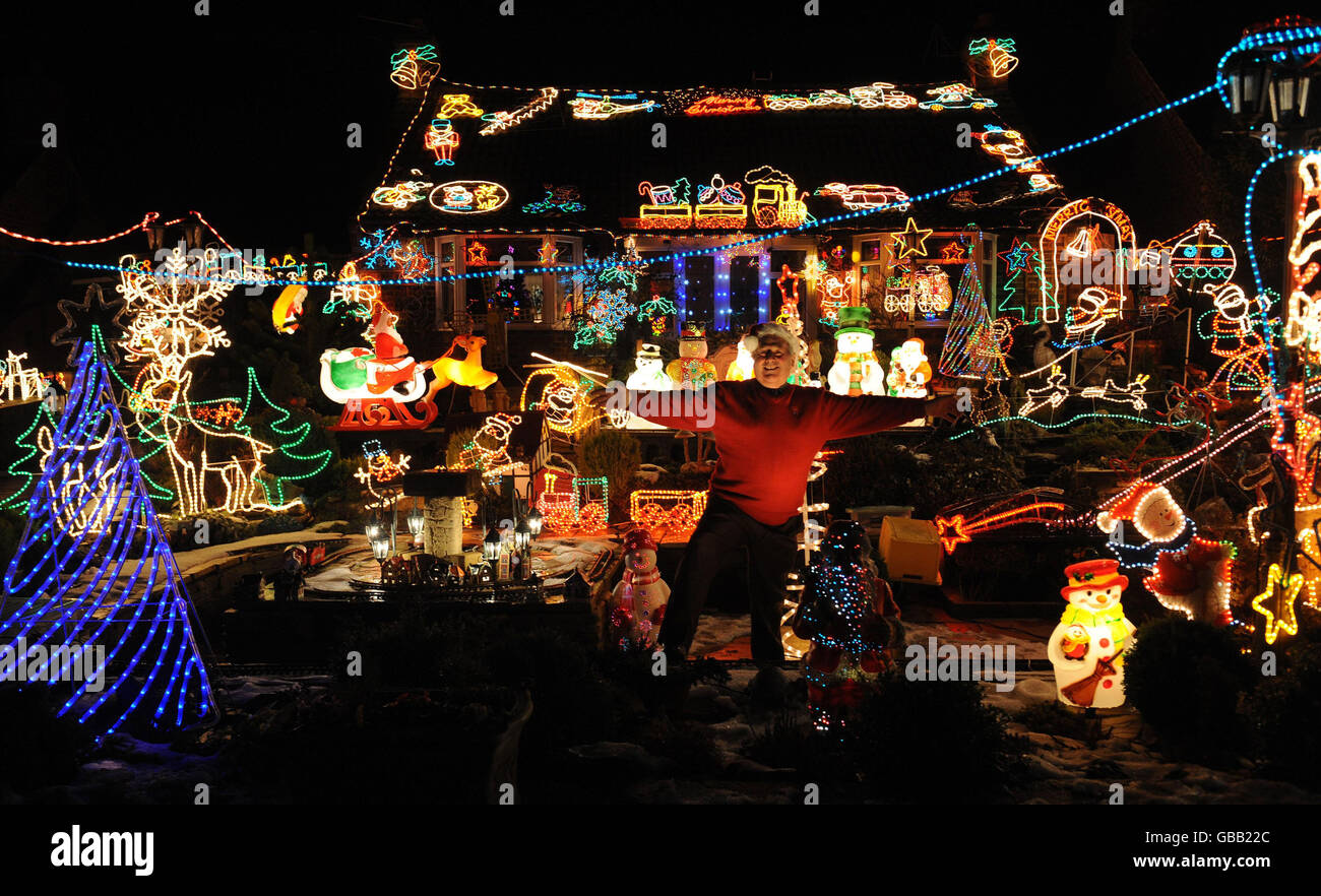 Eric Marshall from Bagby, North Yorkshire, shows off his huge collection of Christmas lights, transforming his front garden, which in the summer is home to a model railway. Stock Photo