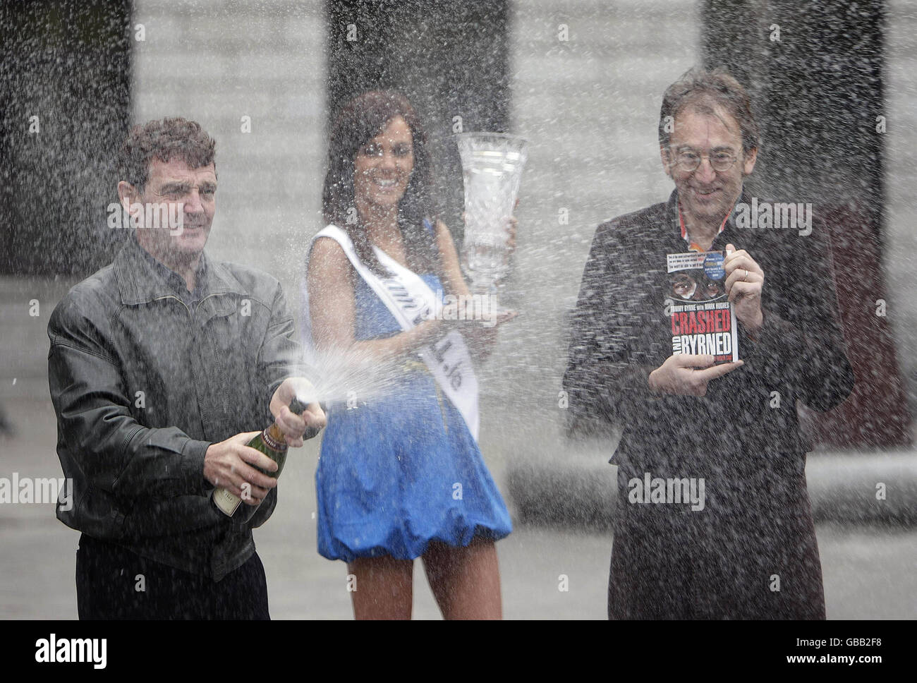 Left to right. Irish Motorsport star Tommy Byrne, model Jenny Devine and author Mark Hughes celebrating Tommy's autobiography Crashed and Byrned in Dublin City Centre. Stock Photo