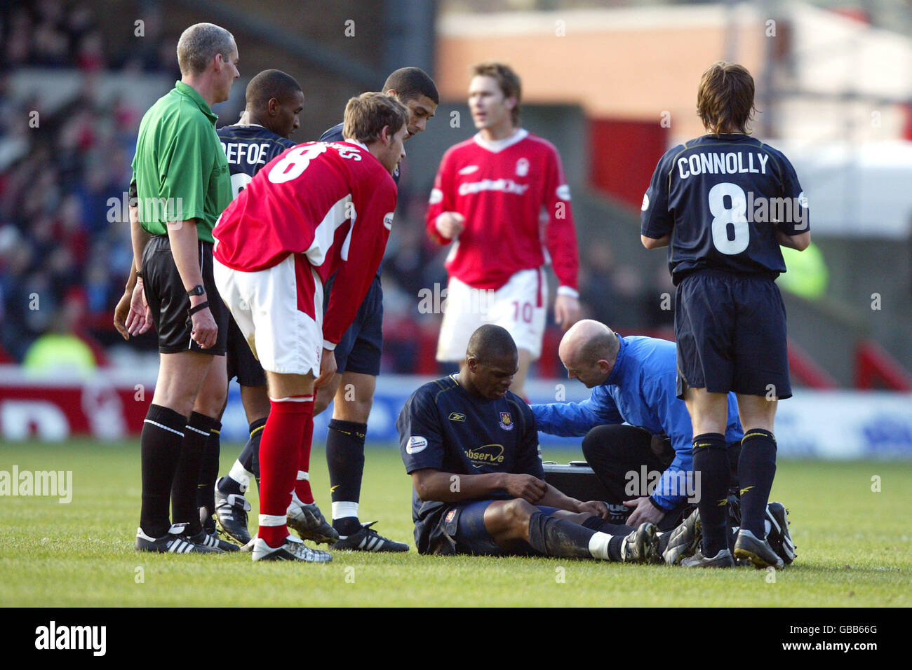 Referee Richard Beeby (l) and others gather as injured West Ham United's Marlon Harewood (floor) is treated by the physio Stock Photo