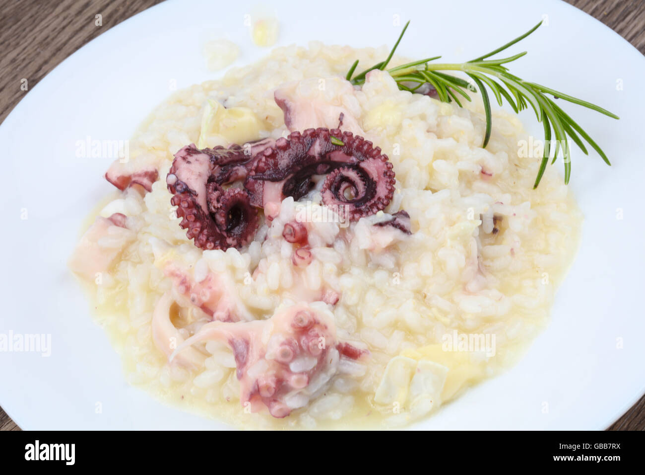 Risotto with octopus served green rosemary Stock Photo - Alamy