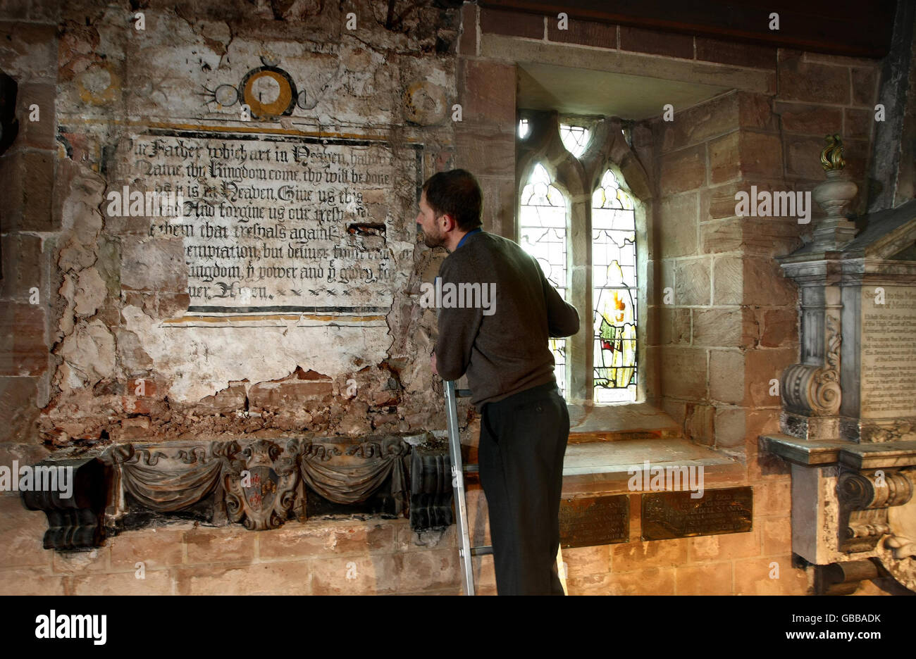 Revd Dr Matthew Rhodes, vicar of St Chad's Church in Wishaw, Warwickshire, with a centuries-old mural of the Lord's Prayer which has been hidden since 1673. Stock Photo