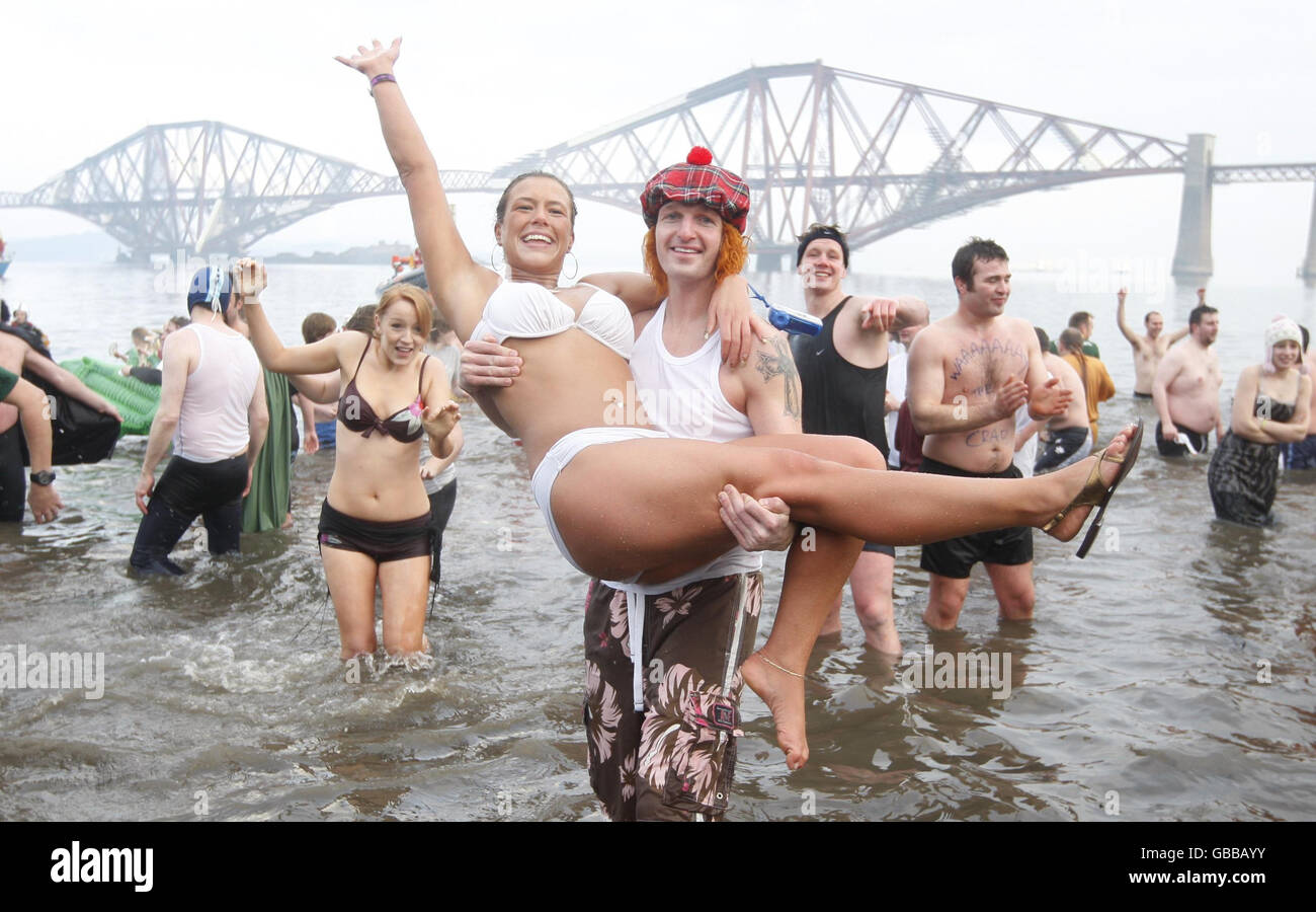 Loony Dookers taking part in the annual charity Loony Dook plunge into the Firth of Forth near the Forth Rail Bridge. Stock Photo