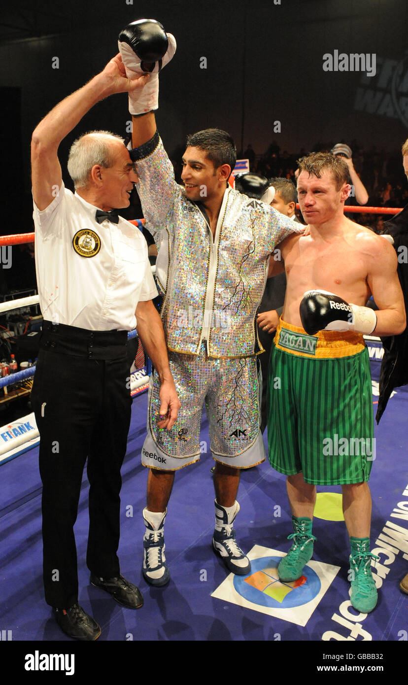Referee Mickie Vann raises Great Britain Amir Khan's arm after his win over Irishman Oisin Fagan (right) in the lightweight bout at the Excel Arena, London. Stock Photo