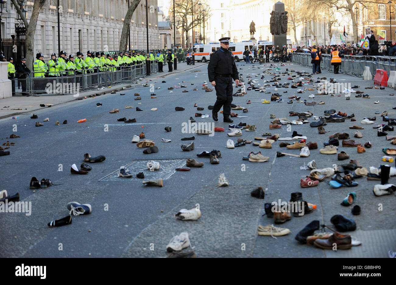 Hundreds of shoes lie in the street in Whitehall after protesters attempted to throw shoes into Downing Street in London. The protesters were demonstrating against the bombing of Gaza and are calling for an immediate end to the Israeli attacks. Stock Photo
