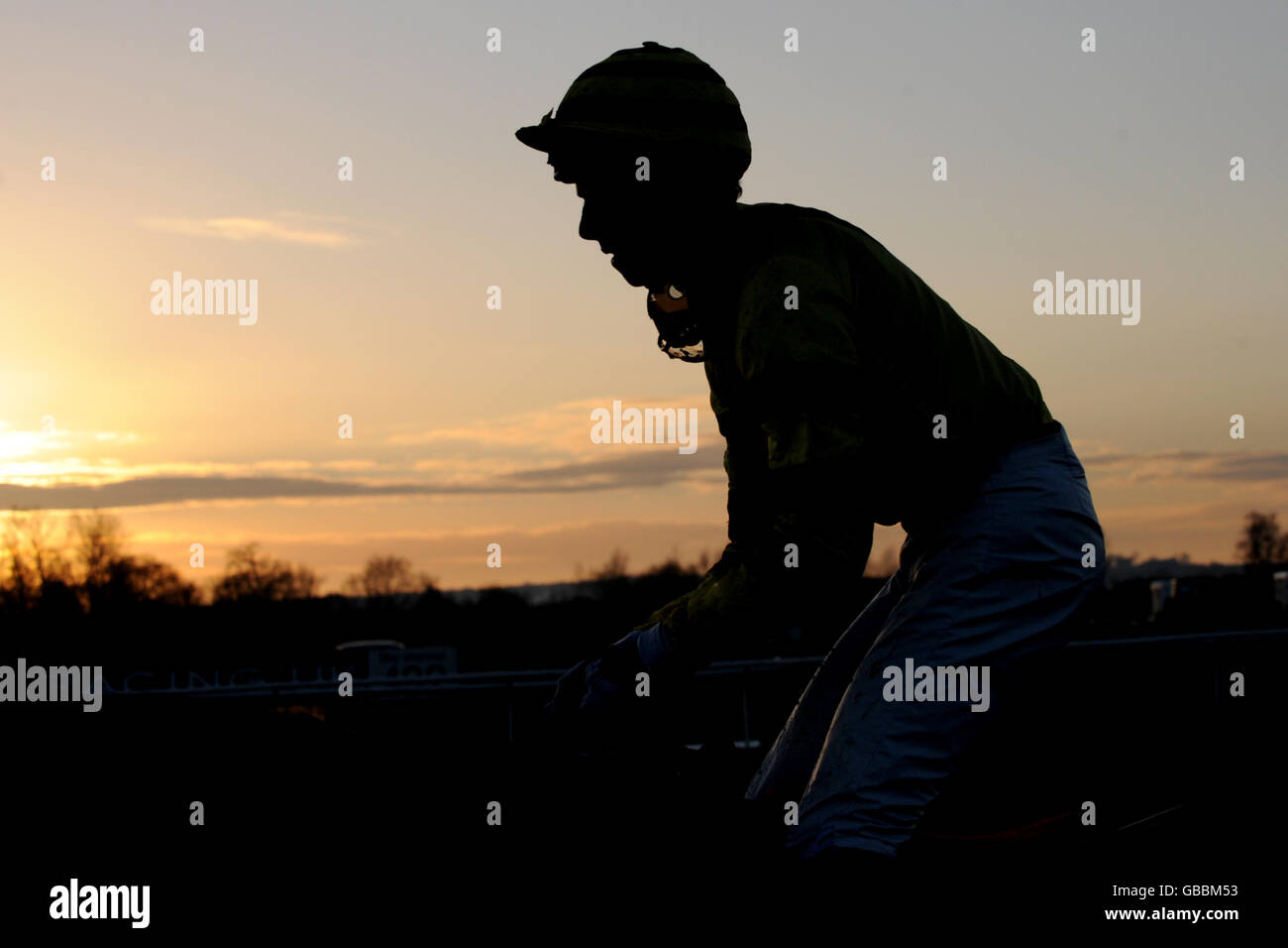 A general view of Horse racing as the rider is seen against the setting sun at Huntingdon Racecourse Stock Photo