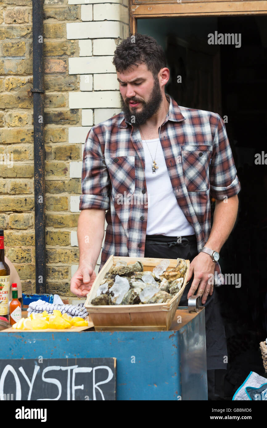 Oyster Boy offering oysters for sale at Columbia Road market, London UK in July Stock Photo