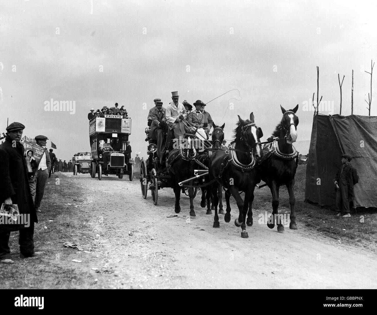 A horse-drawn coach and motor bus arriving at Epsom for The Derby in 1913. Stock Photo