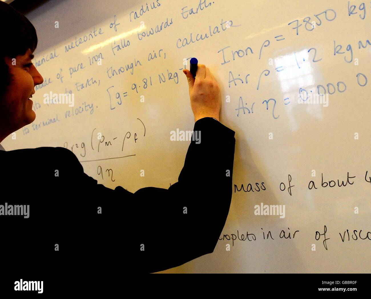 A tear 12 student writes on a white board during a physics class at the top school in the country, Lawrence Sheriff School in Rugby, after the league tables for English schools was released today. Stock Photo