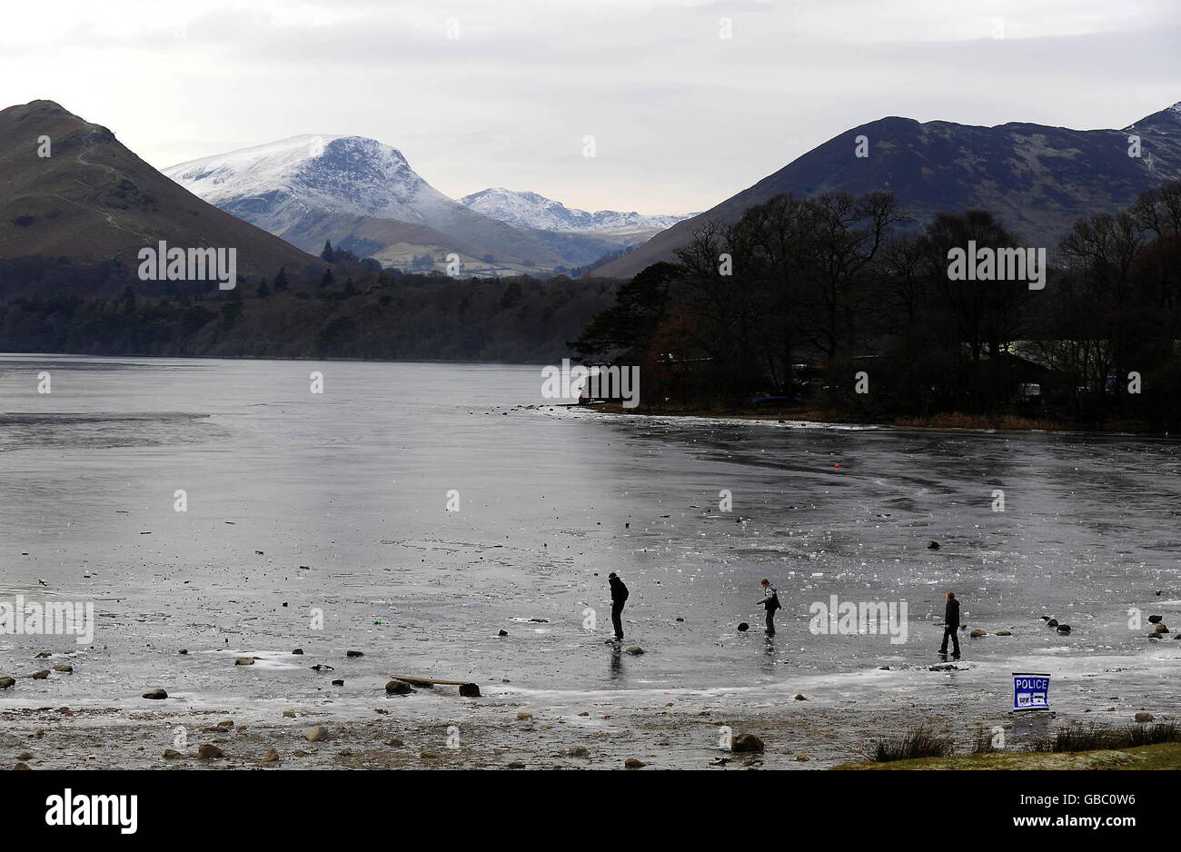 Derwentwater near Keswick frozen solid with a Police Ice warning sign today as the cold spell continues. Stock Photo