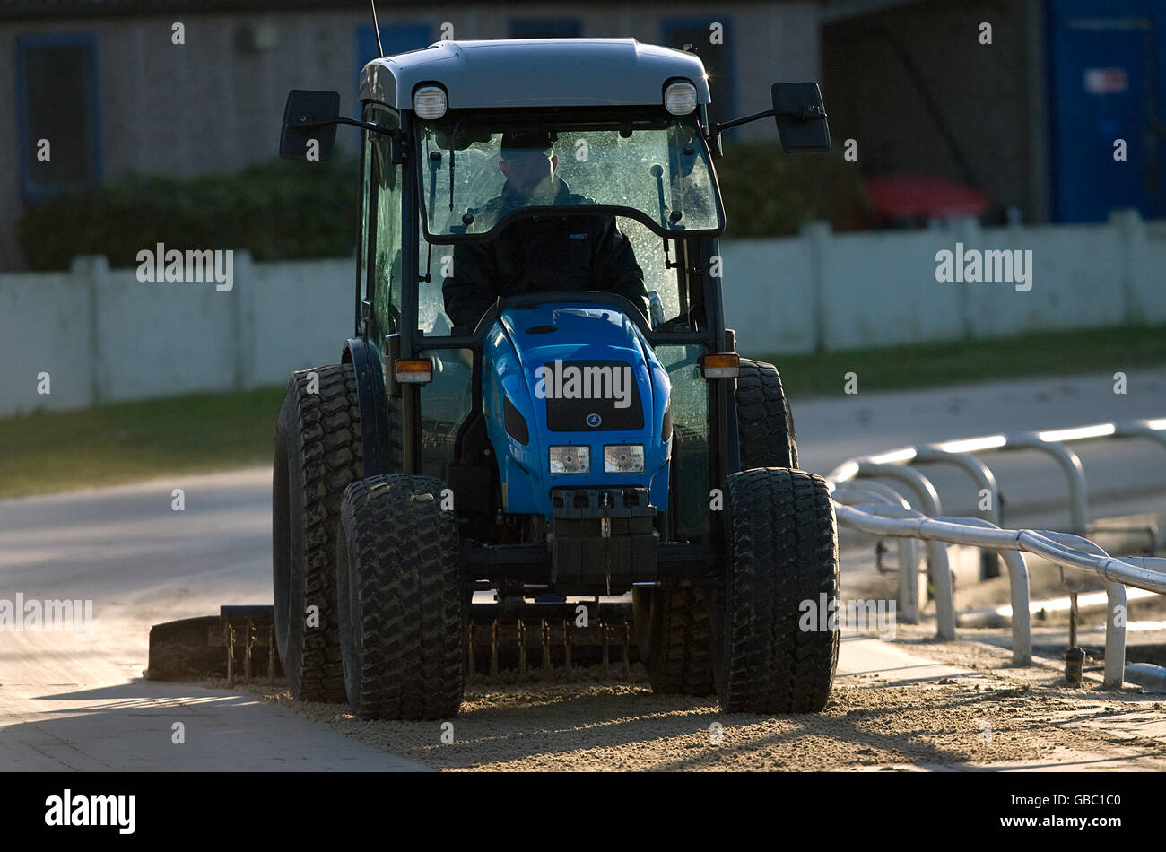 A tractor smooths out the racing track at the Coral Brighton and Hove Greyhound Stadium in West Sussex. Stock Photo