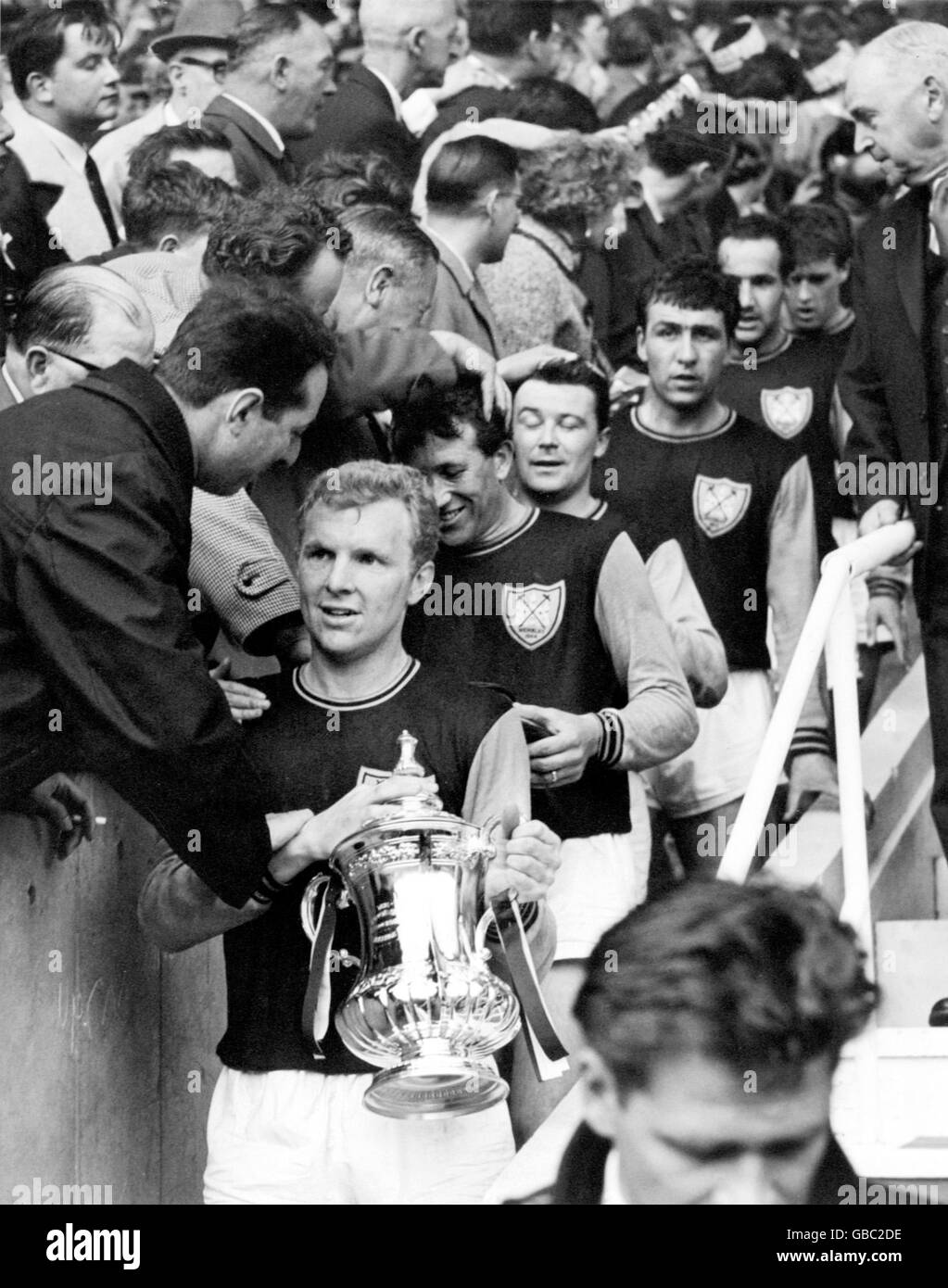 West Ham United captain Bobby Moore carries the FA Cup down the steps after his team's 3-2 victory, followed by teammates (top to bottom) Ken Brown, Johnny Byrne, Peter Brabrook, Eddie Bovington and Geoff Hurst Stock Photo