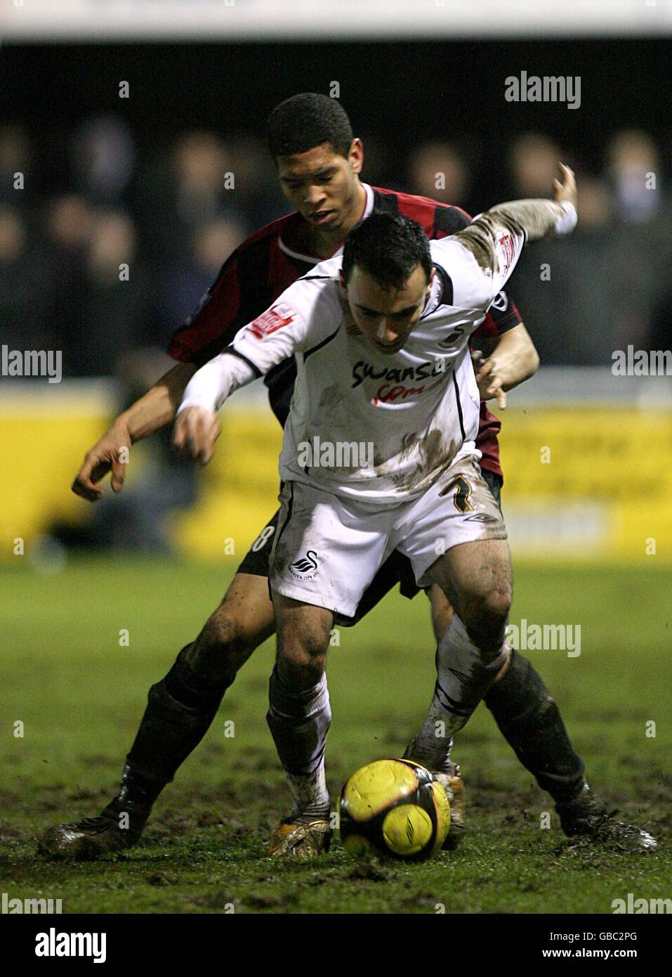 Soccer - FA Cup - Third Round Replay - Histon v Swansea City - The Glassworld Stadium. Swansea City's Leon Britton and Histon's Nathaniel Knight-Percival (back) battle for the ball Stock Photo