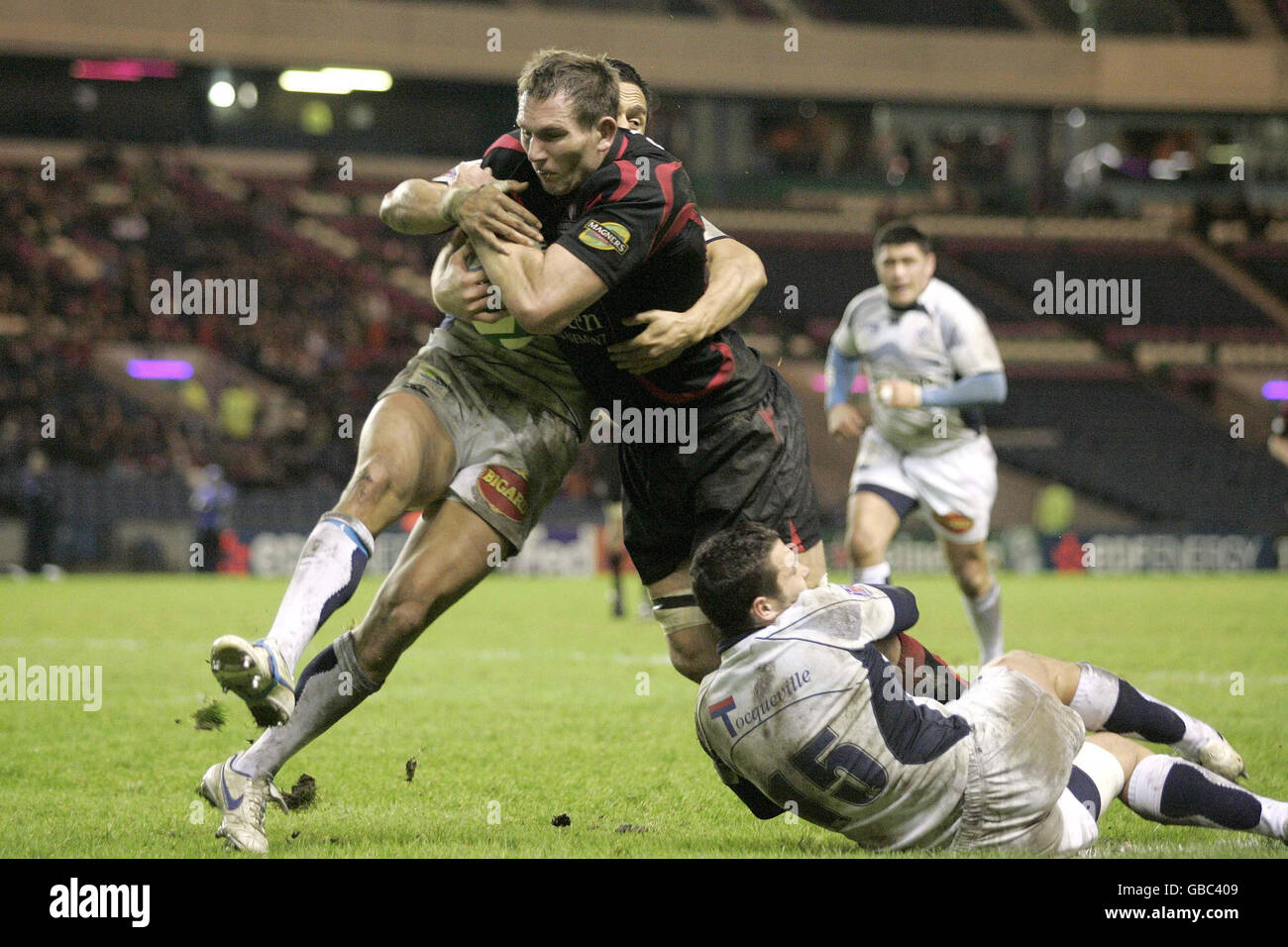 Ben Gissing of Edinburgh tackled by Kevin Senio and (15) Thomas Bouquie of Castres during the Heineken Cup Pool Two match at Murrayfield, Edinburgh. Stock Photo