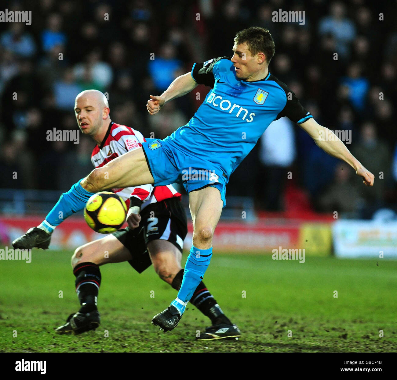 Doncaster's James O'Connor and Aston Villa's James Milner battle for the ball during the FA Cup, Fourth Round at Keepmoat Stadium, Doncaster. Stock Photo
