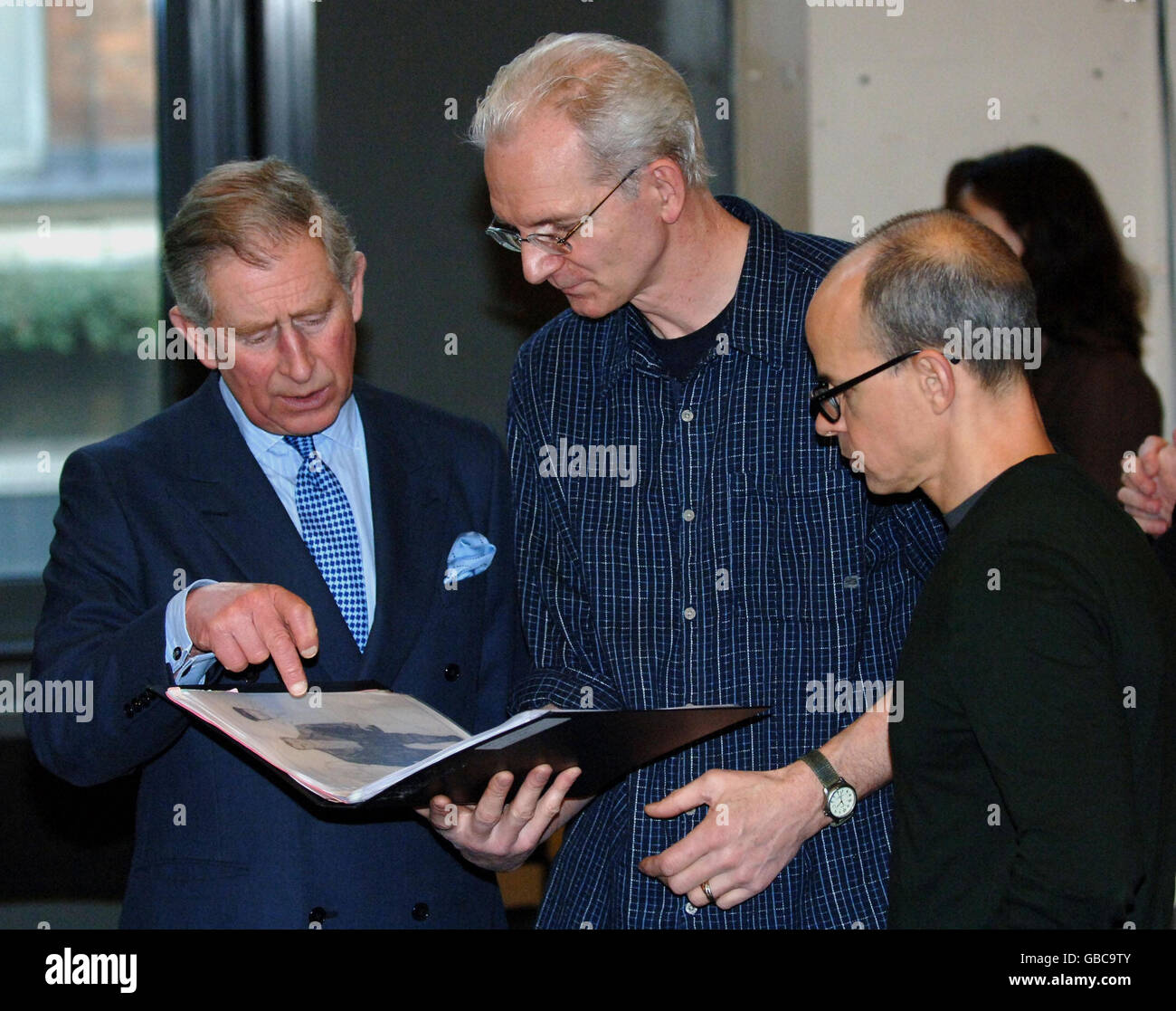 The Prince of Wales (left) is shown the score of opera The Flying Dutchman, by Production Director Tim Albery (centre), and set designer Michael Levine during a visit to London's Royal Opera House. Stock Photo