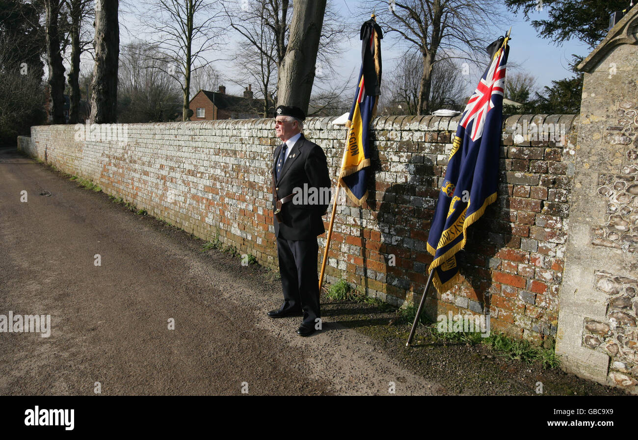 A British Legion standard bearer waits for the start of the funeral