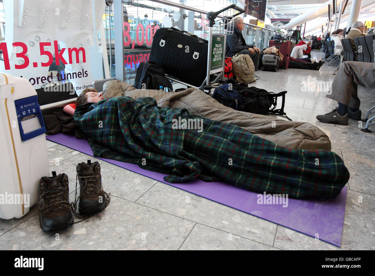 Passengers sleep on the floor of Terminal 5 at Heathrow Airport after