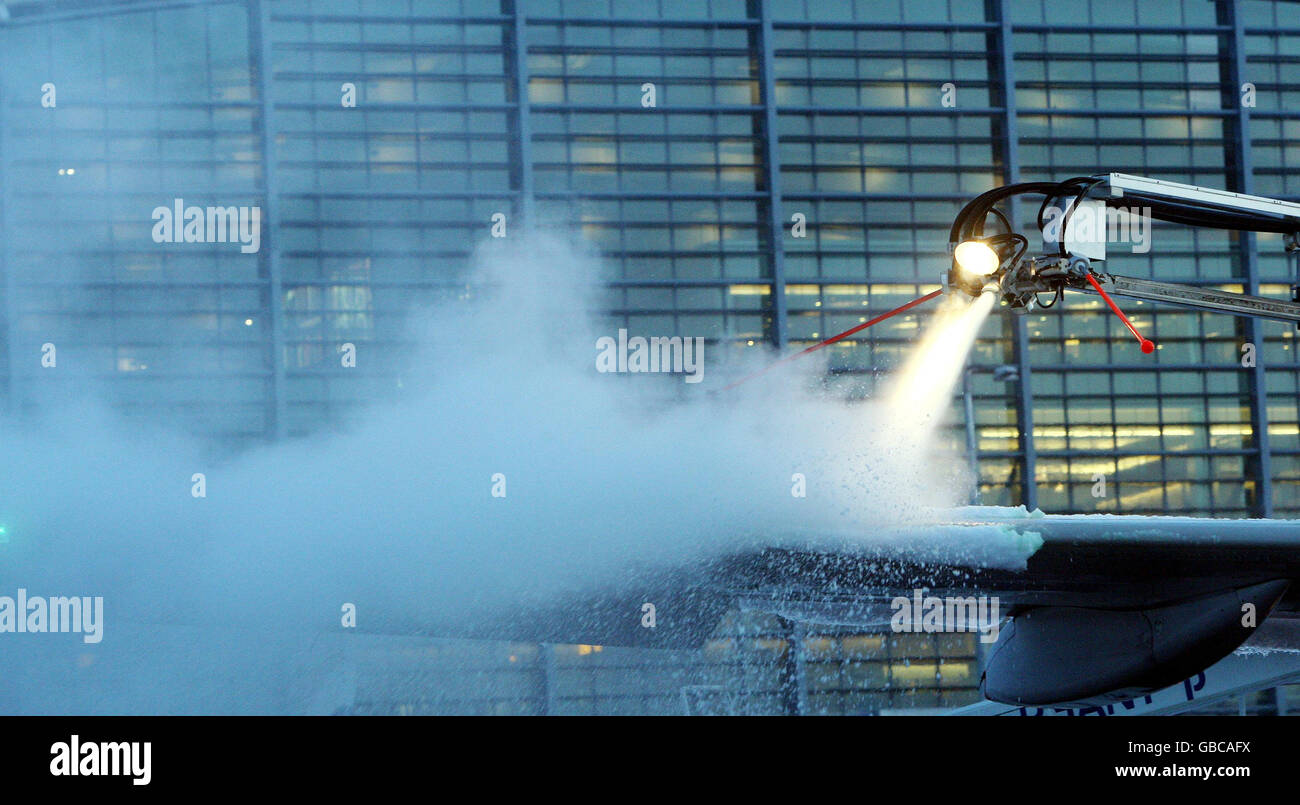 Engineers from British Airways deice a plane to prepare it for take