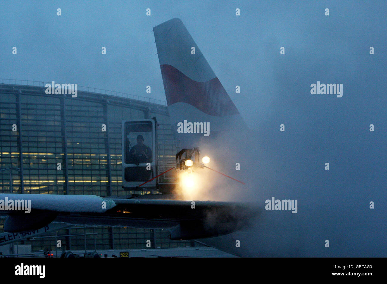 Engineers from British Airways deice a plane to prepare it for take