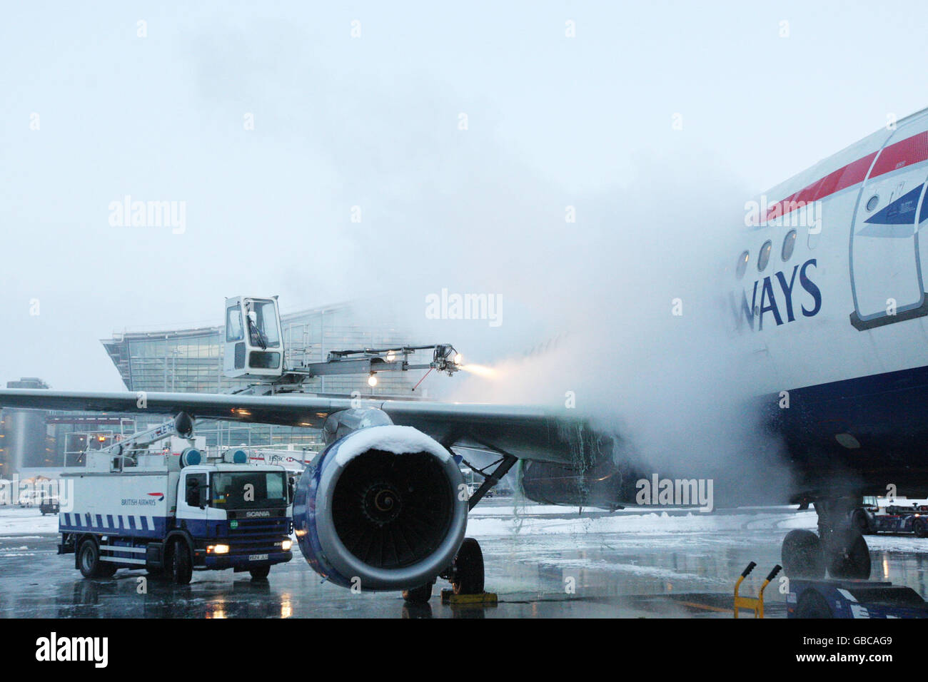 Engineers from British Airways deice a plane to prepare it for take
