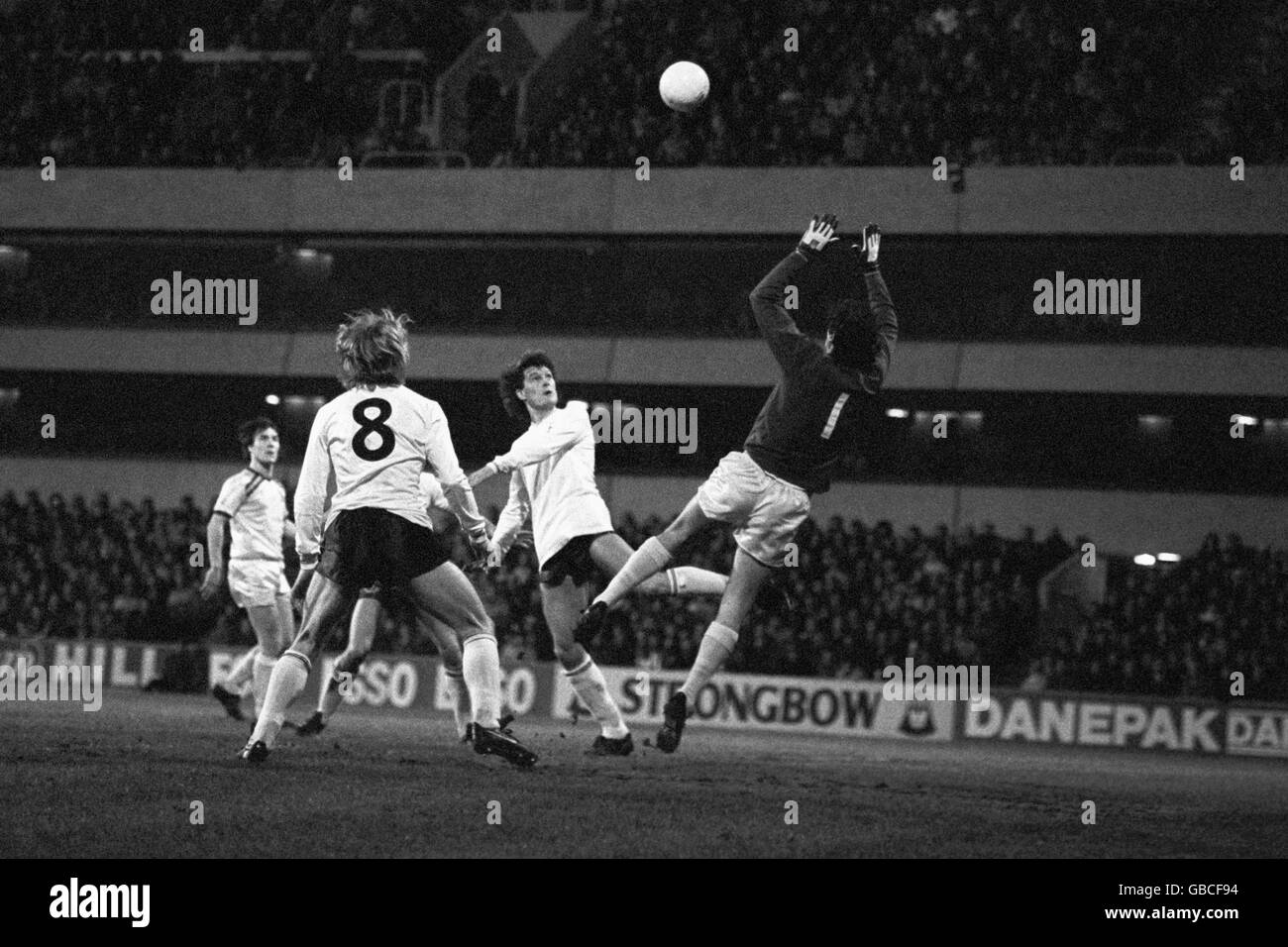 Tottenham Hotspur's Glenn Hoddle (second right) taps the ball goal-wards, but hits the bar with Burnley goalkeeper Alan Stevenson (r) at the ready and Hoddle's team-mate Steve Archibald (8) in support in the early stages of the Milk Cup quarter final. Burnley won the match 4-1. Also pictured (far left) is Burnley's Derek Scott. Stock Photo