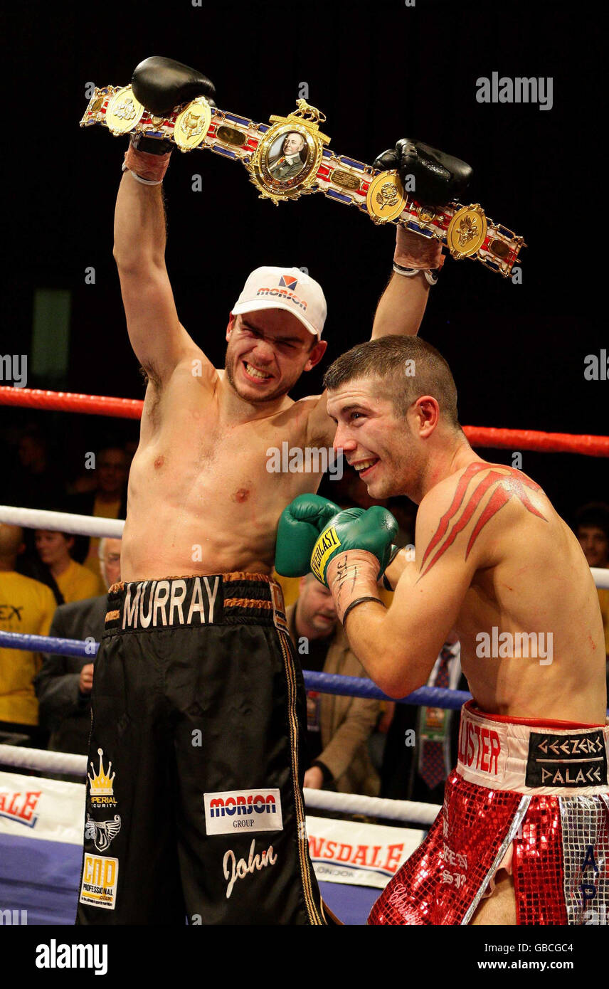 John Murray holds the belt as Lee McAllister lands a playful body shot at the British Lightweight Title fight at the Robin Park Centre, Wigan. Stock Photo