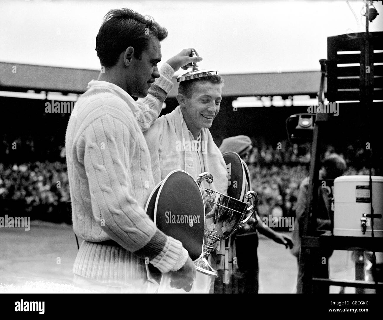 (L-R) Runner up Kurt Nielsen places the lid of the men's singles trophy on the head of champion Tony Trabert Stock Photo