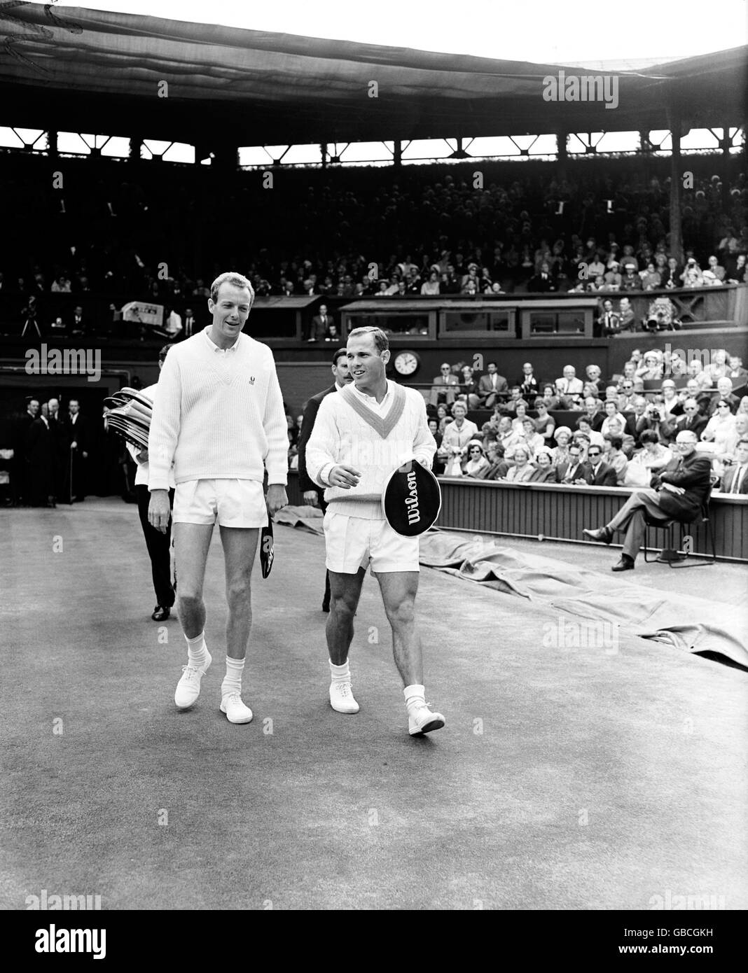 (L-R) Fred Stolle and Chuck McKinley make their way onto court for the final Stock Photo