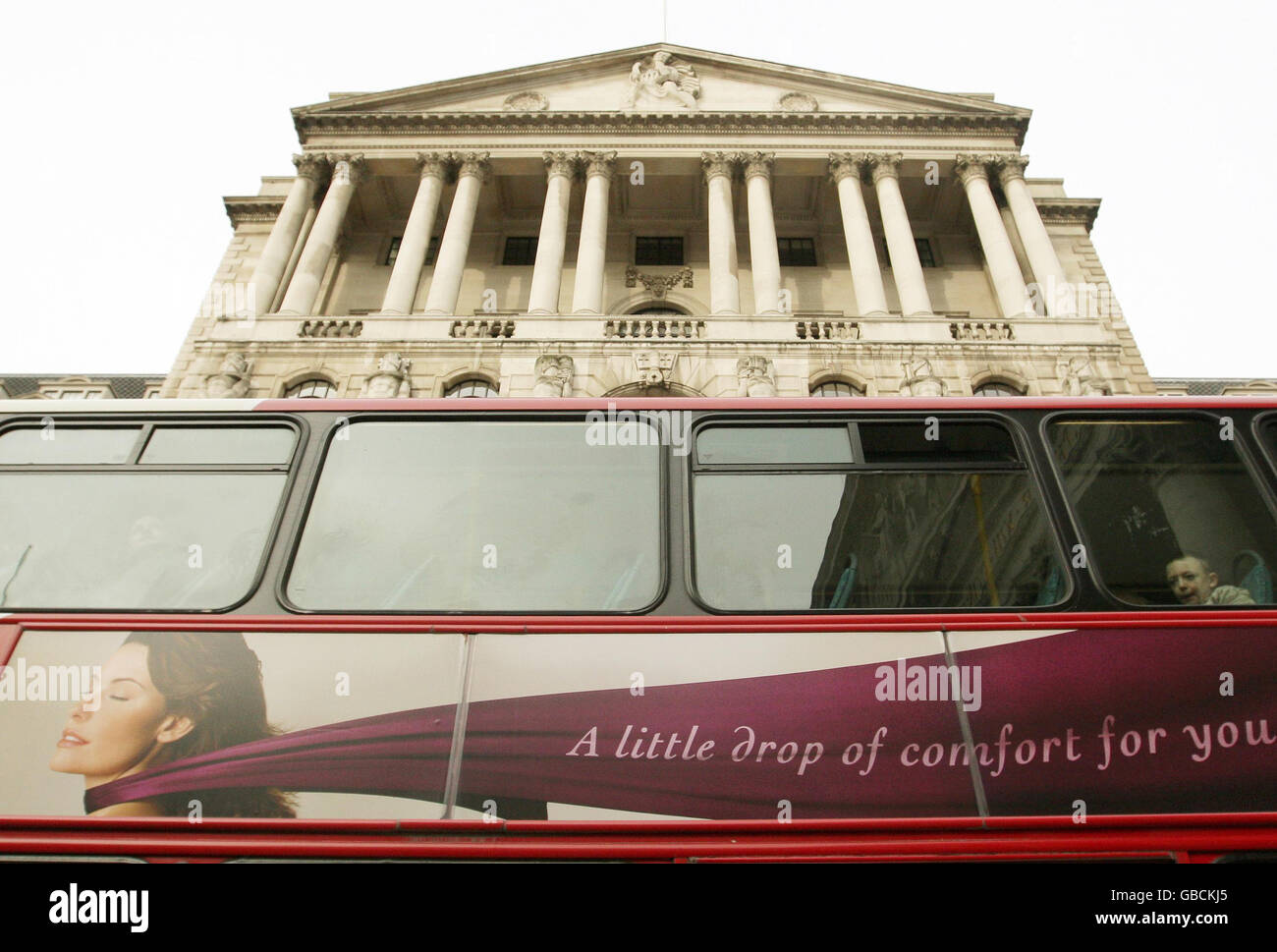 A London bus passes in front of the Bank of England, central London. Stock Photo