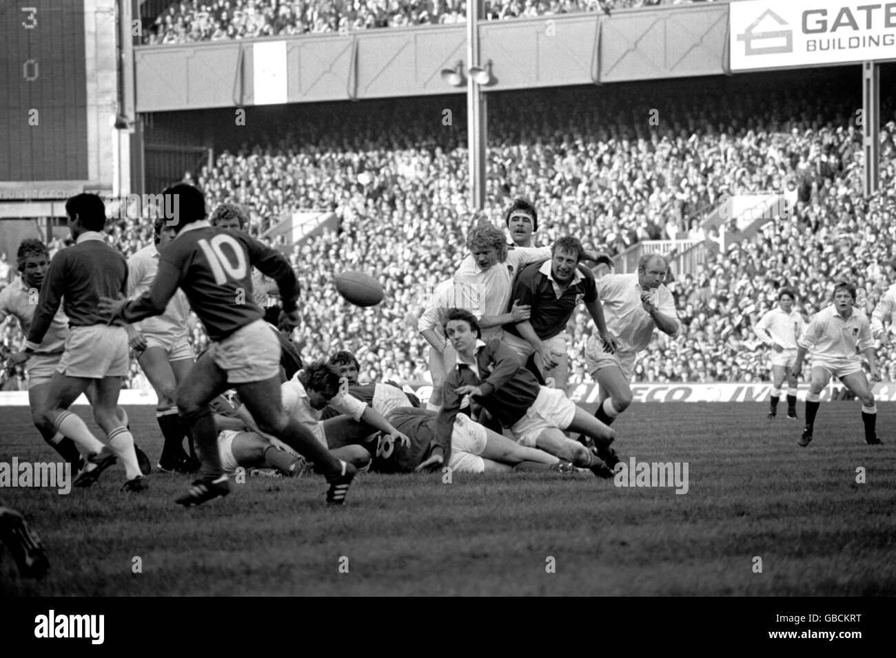 Ireland's Tony Doyle (c, falling) passes the ball to teammate Tony Ward (10), watched by teammate Moss Keane (third r) and England's Rory Underwood (r, far background), David Cooke (fifth r), Steve Bainbridge (fourth r), Phil Blakeway (l, behind ref), Colin White (second r) Stock Photo