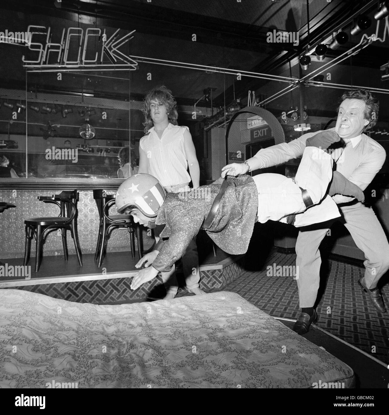 A besuited punter tries his hand at dwarf tossing in Shakes Disco, Croydon Stock Photo