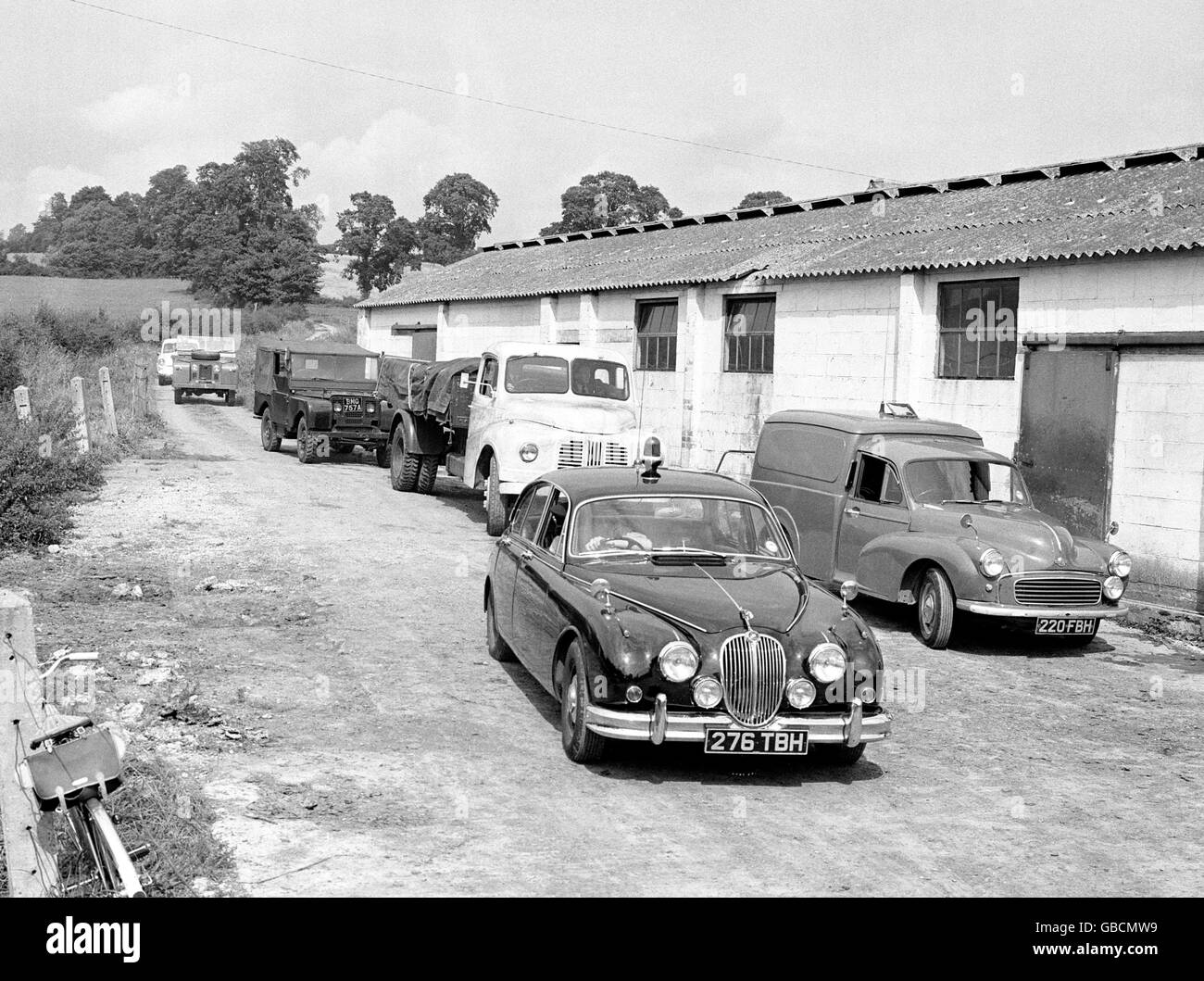 A police-car escorts the lorry and two Land Rovers, which police believe the bandits carried much or all of their haul after the 2.6 million pound mail train robbery, out of Leatherslade Farm, Oakley, Bukinghamshire, where the gang hid after the crime. Stock Photo