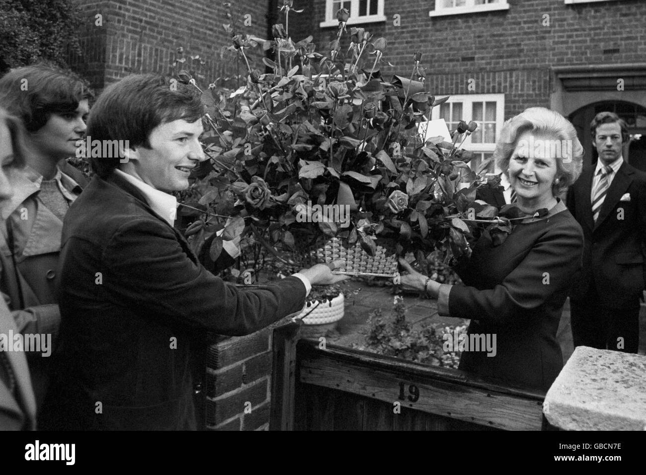 Mike Forsyth, national chairman of the Federation of Conservative Students, presents Conservative leader Margaret Thatcher with 51 red roses at her London home on the occasion of her 51st birthday. Stock Photo