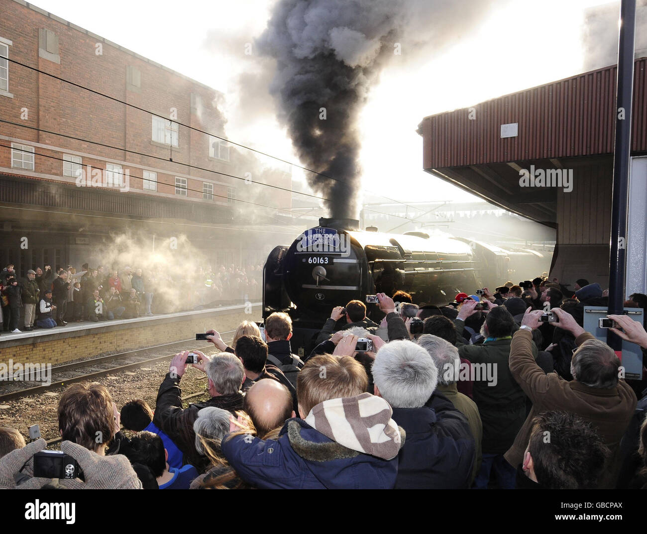 Enthusiasts pack the platforms of York Station as the Peppercorn class A1 60163 Tornado leaves the station. Stock Photo
