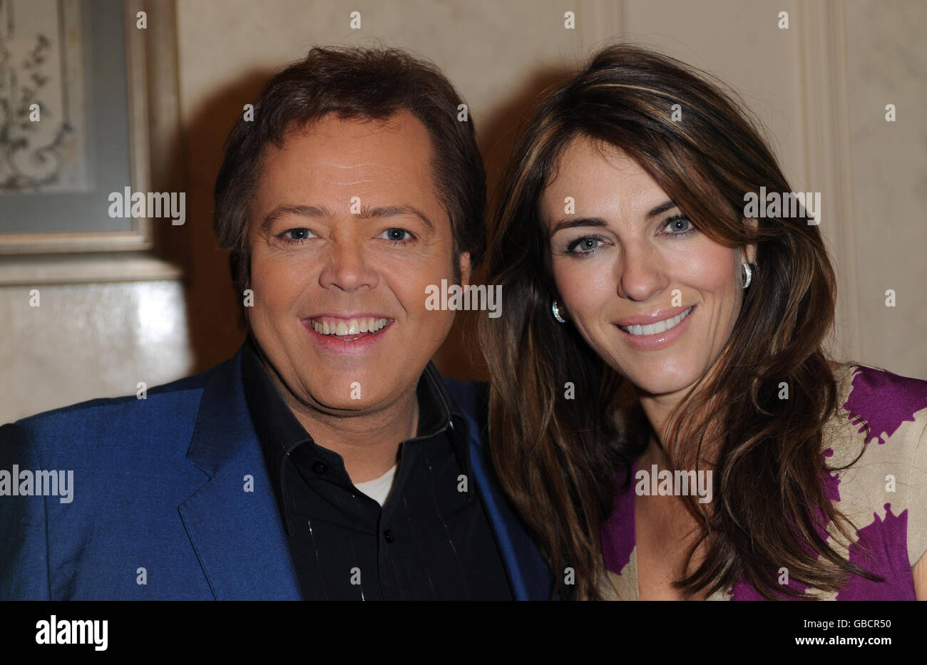 Grease fan Elizabeth Hurley pops backstage to meet her 'Teen Angel' Jimmy Osmond, currently starring in the smash-hit musical at the Piccadilly Theatre in central London. Elizabeth confesses to having had a life size poster of Jimmy stuck to her bedroom wall when she was nine. Last year, Grease raised 500,000 for Macmillan Cancer support and as a patron of the charity Elizabeth accepted the cheque on their behalf. Stock Photo