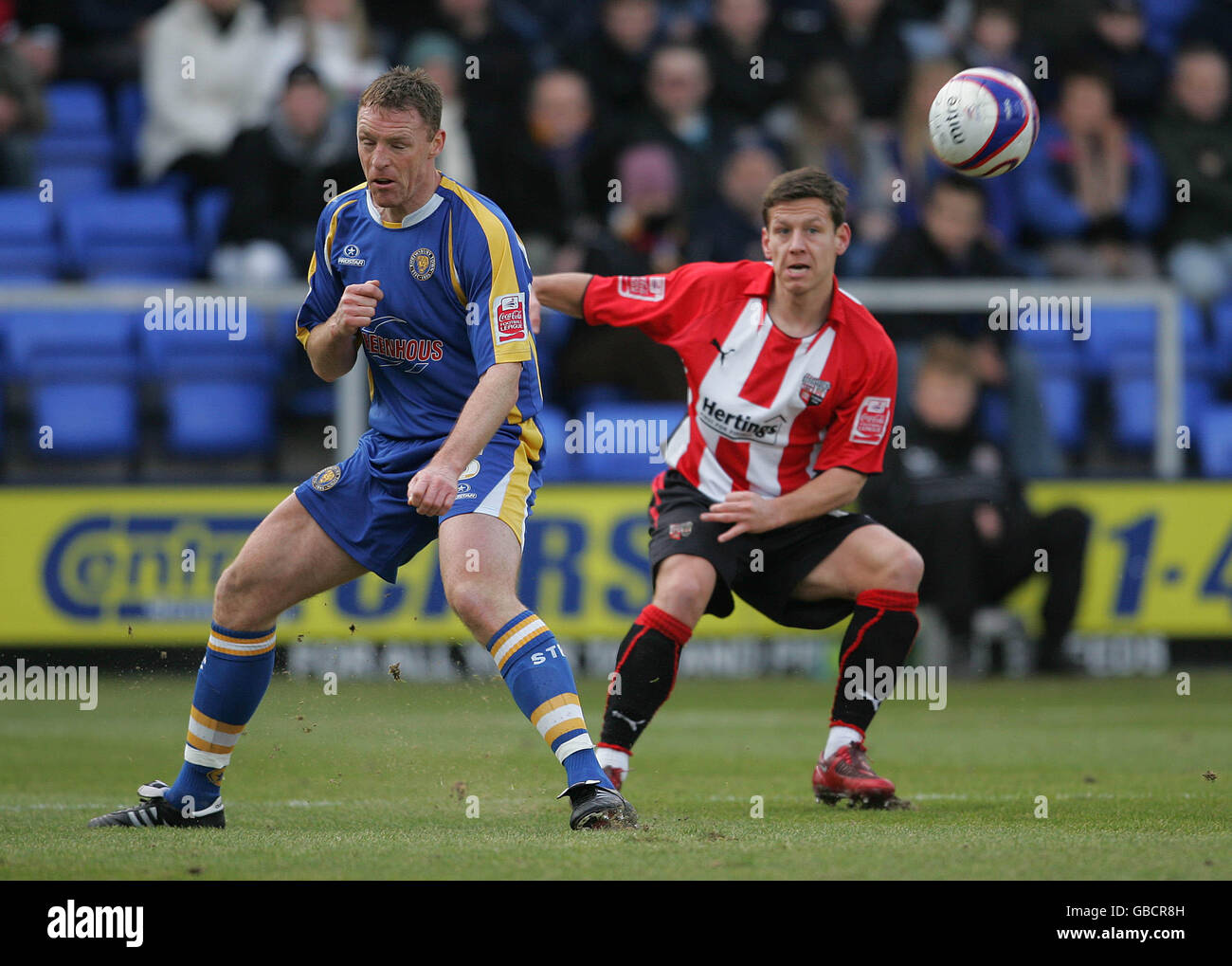 Brentford's Mark Phillips and Shrewsbury Town's James Constable during the Coca-Cola League Two match at the Prostar Stadium, Shrewsbury. Stock Photo