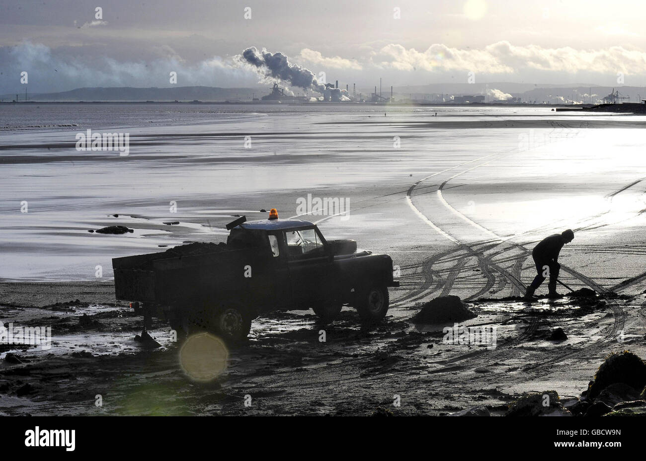 Sea coal is scraped from a beach in Hartlepool and loaded onto a truck. Several tons of coal is dumped on the beaches from seams out at sea and provides income for those prepared to brave the elements. Stock Photo